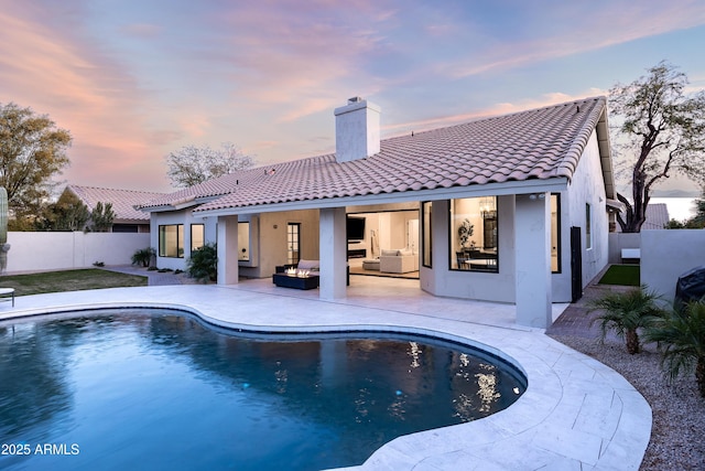 back of house with a fenced in pool and a patio