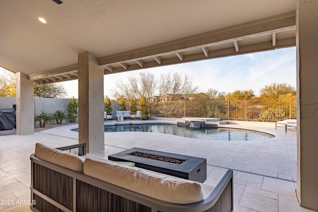 view of patio / terrace with a swimming pool with hot tub and an outdoor living space with a fire pit