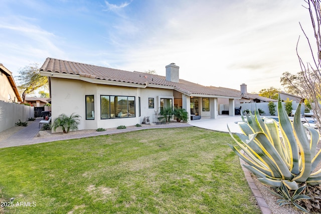 back of property with a patio and a lawn