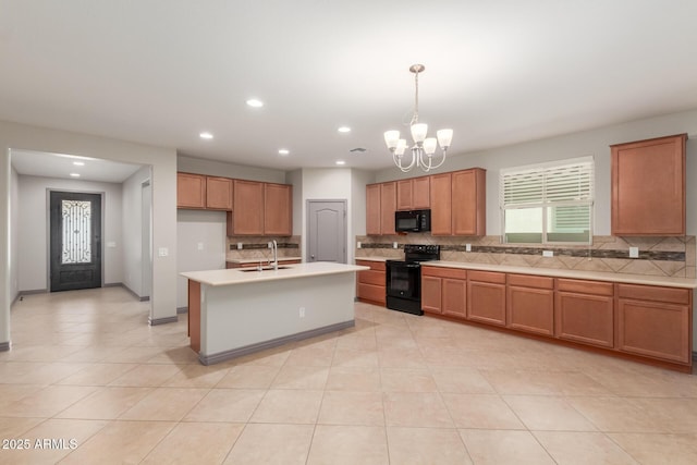 kitchen featuring light countertops, brown cabinets, a sink, black appliances, and a notable chandelier