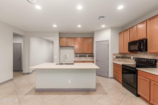 kitchen with visible vents, black appliances, light countertops, and a sink