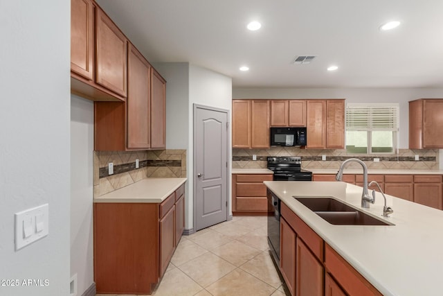 kitchen featuring a sink, visible vents, light countertops, and black appliances