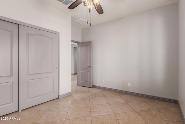 unfurnished bedroom with a closet, baseboards, visible vents, and light tile patterned floors