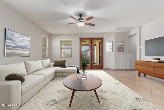 living room featuring light tile patterned flooring, baseboards, visible vents, and ceiling fan