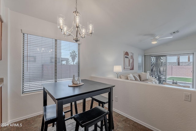 dining space with lofted ceiling, a ceiling fan, baseboards, and a chandelier