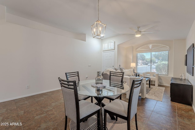 dining area featuring ceiling fan, a chandelier, baseboards, and lofted ceiling