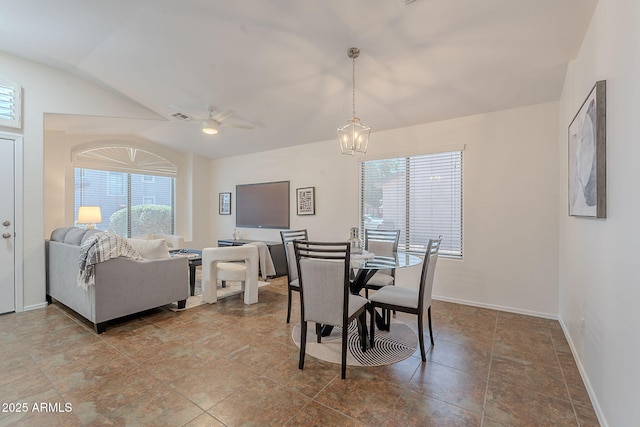 dining area featuring lofted ceiling, ceiling fan, baseboards, and a chandelier