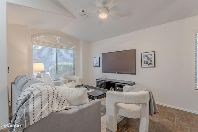 living area featuring vaulted ceiling, a ceiling fan, baseboards, and stone finish floors