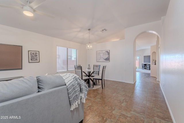 living room with arched walkways, vaulted ceiling, baseboards, and a ceiling fan