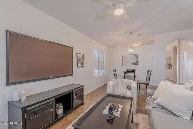 living room with arched walkways, lofted ceiling, ceiling fan, and baseboards