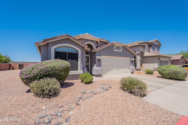 view of front of property with stucco siding, an attached garage, concrete driveway, and a tiled roof
