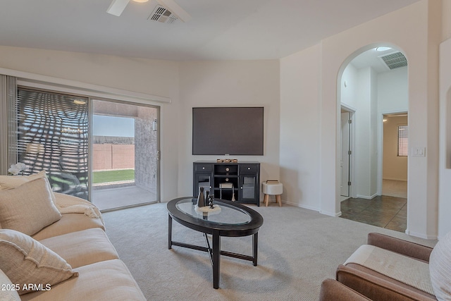 carpeted living area featuring arched walkways