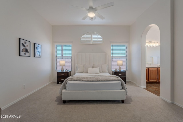 bedroom with carpet flooring, multiple windows, arched walkways, and baseboards