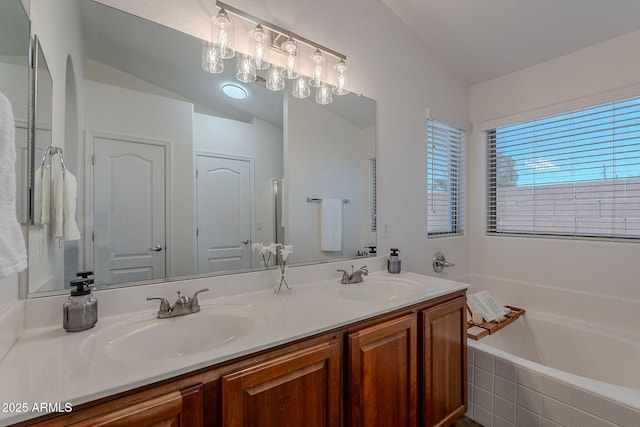 full bath with double vanity, a garden tub, and lofted ceiling