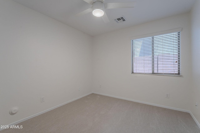 empty room featuring light colored carpet, ceiling fan, and baseboards