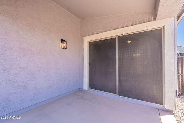 doorway to property featuring stucco siding and a patio area