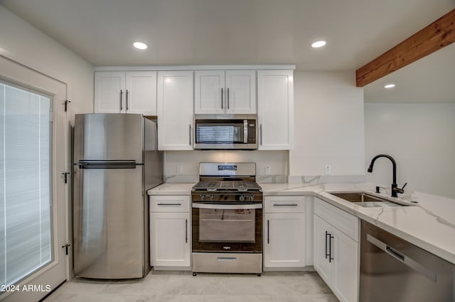 kitchen with sink, white cabinetry, and stainless steel appliances