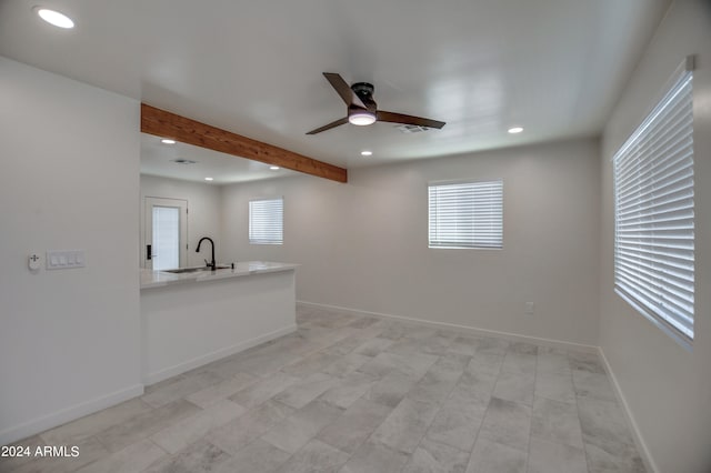 interior space featuring beamed ceiling, sink, and ceiling fan