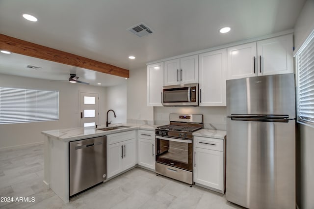 kitchen featuring kitchen peninsula, appliances with stainless steel finishes, white cabinets, and ceiling fan