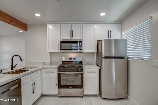 kitchen featuring light tile flooring, white cabinetry, stainless steel appliances, sink, and light stone counters