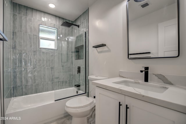 full bathroom featuring large vanity, toilet, and tiled shower / bath