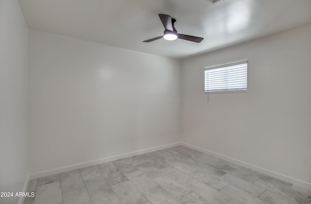 tiled spare room with ceiling fan