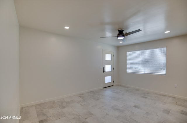 tiled empty room featuring ceiling fan