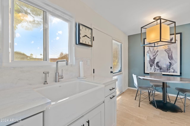 4620 N 68th St Unit 136, Scottsdale, AZ 85251 - kitchen featuring a sink, light wood finished floors, white cabinets, and plenty of natural light