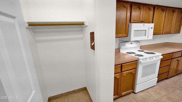 kitchen with light tile patterned floors and white appliances