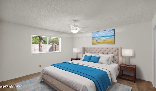 carpeted bedroom featuring ceiling fan and a textured ceiling