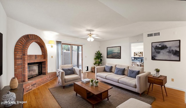 living room featuring a fireplace, lofted ceiling, hardwood / wood-style floors, and ceiling fan