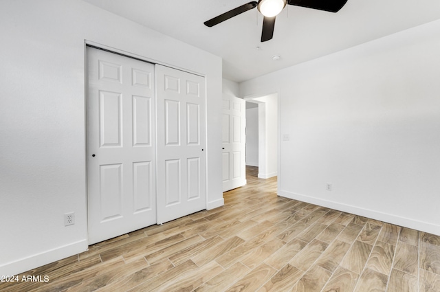 unfurnished bedroom featuring a closet, light hardwood / wood-style flooring, and ceiling fan