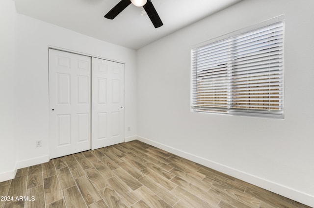 unfurnished bedroom featuring a closet, light hardwood / wood-style floors, and ceiling fan