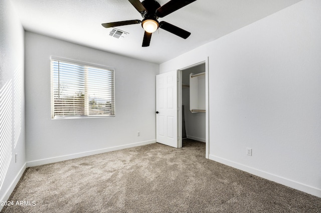 unfurnished bedroom with a closet, light colored carpet, and ceiling fan