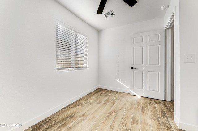 empty room with ceiling fan and light hardwood / wood-style flooring