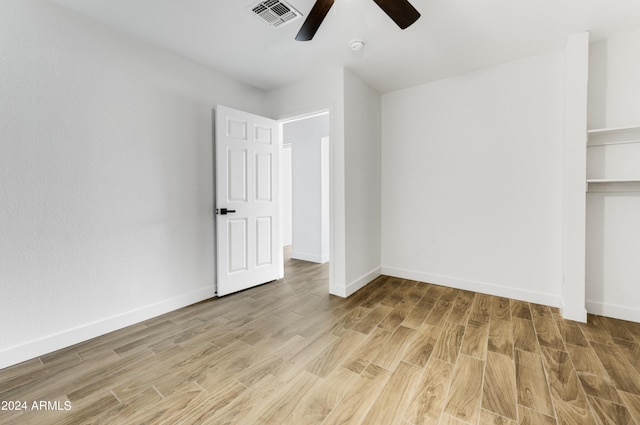 unfurnished bedroom featuring ceiling fan, a closet, and light wood-type flooring