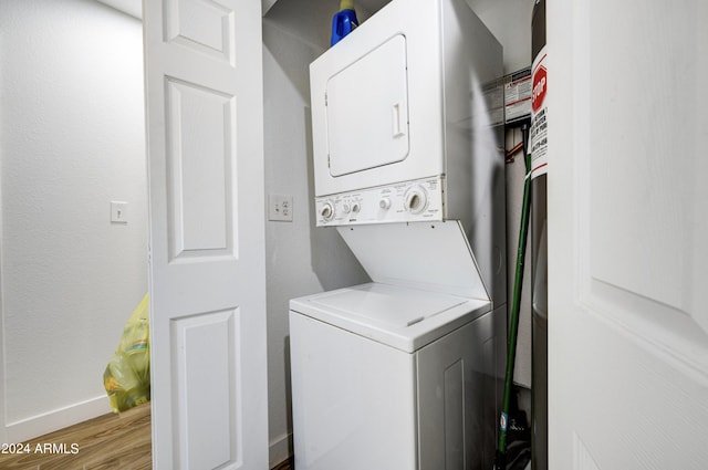 laundry area with stacked washer / dryer and light wood-type flooring