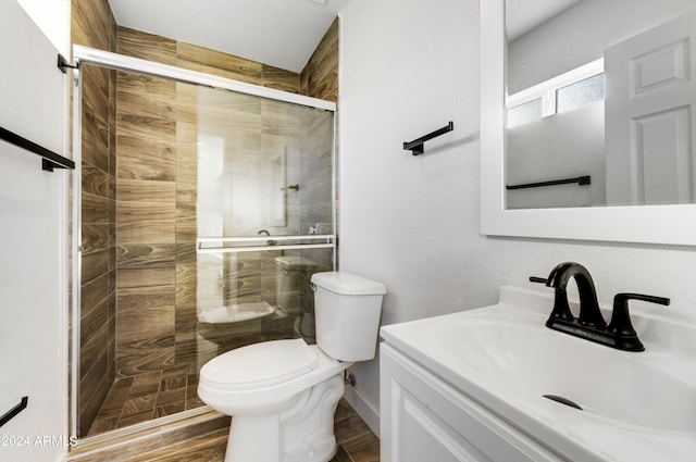 bathroom with walk in shower, toilet, vanity, and hardwood / wood-style flooring