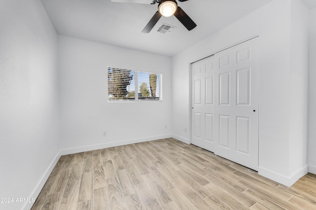 unfurnished bedroom featuring a closet, light hardwood / wood-style flooring, and ceiling fan