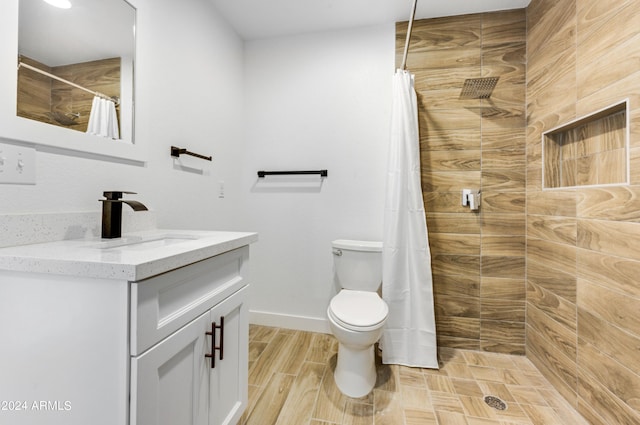 bathroom with toilet, vanity, wood-type flooring, and walk in shower