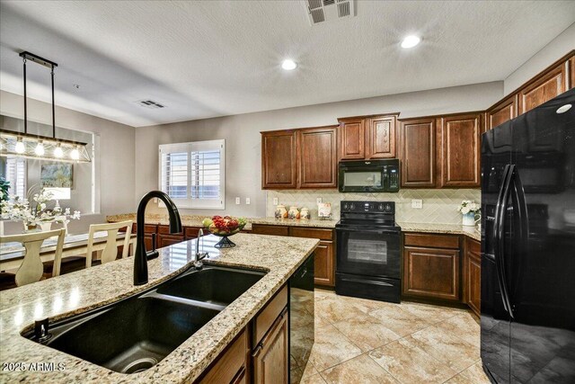 31133 N 132nd Ln, Peoria, AZ 85383 - kitchen featuring black appliances, tasteful backsplash, hanging light fixtures, light stone countertops, and recessed lighting