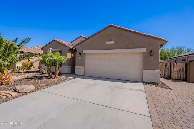 13523 W Remuda Dr, Peoria, AZ 85383 - mediterranean / spanish-style house with driveway, stucco siding, an attached garage, a tiled roof, and fence