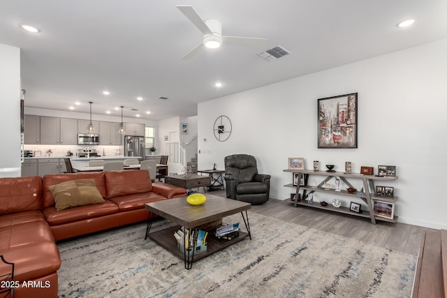 living room featuring ceiling fan and light wood-type flooring