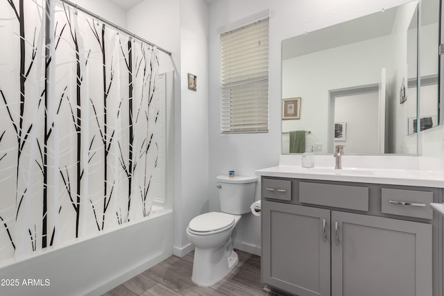 full bathroom with hardwood / wood-style floors, vanity, toilet, and shower / bath combo with shower curtain