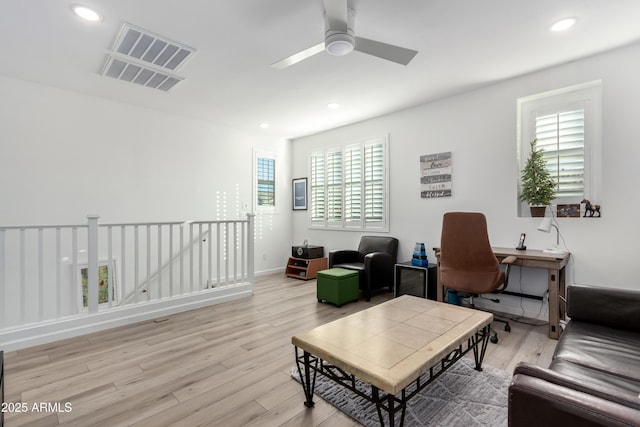 living room with light wood-type flooring, a wealth of natural light, and ceiling fan