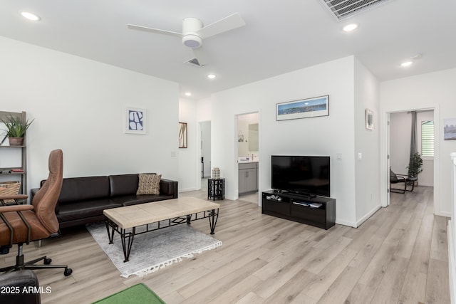 living room with ceiling fan and light hardwood / wood-style flooring