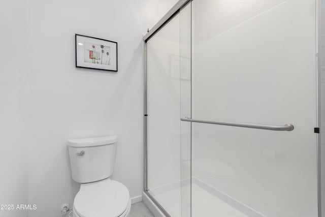 bathroom with toilet and a shower with shower door