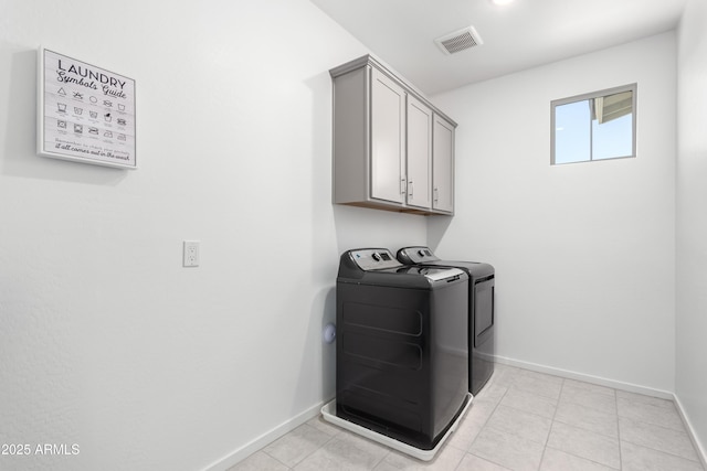 clothes washing area featuring cabinets and separate washer and dryer