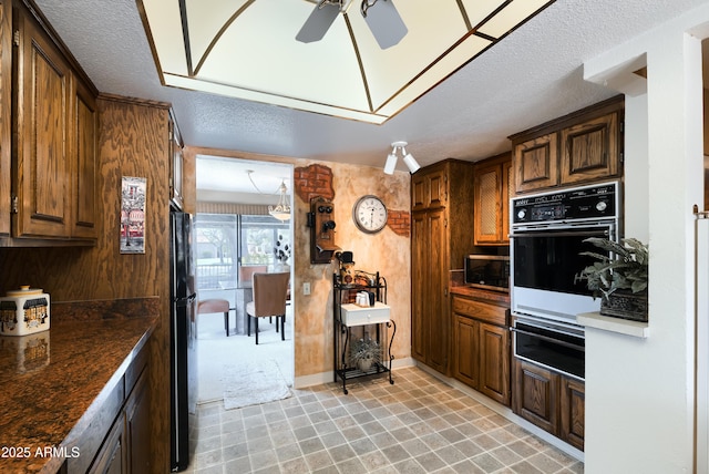 365 Leisure World, Mesa, AZ 85206 - kitchen with black appliances, a warming drawer, a ceiling fan, dark countertops, and a textured ceiling