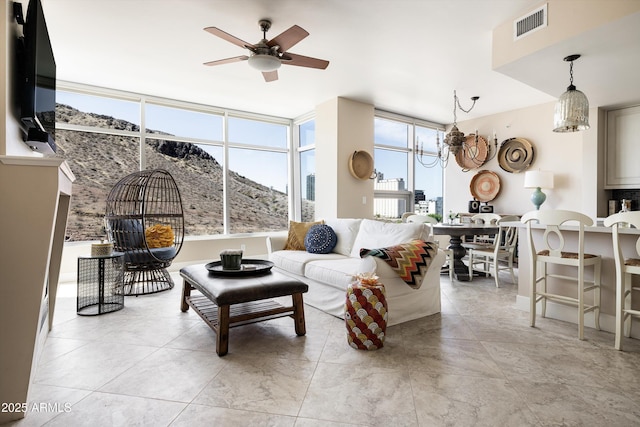 living area featuring ceiling fan, a chandelier, and light tile patterned floors